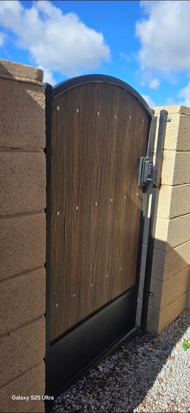 Arched pedestrian gate in dark steel