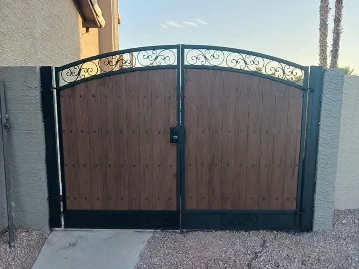 Arched wood gate with ornamental steel top
